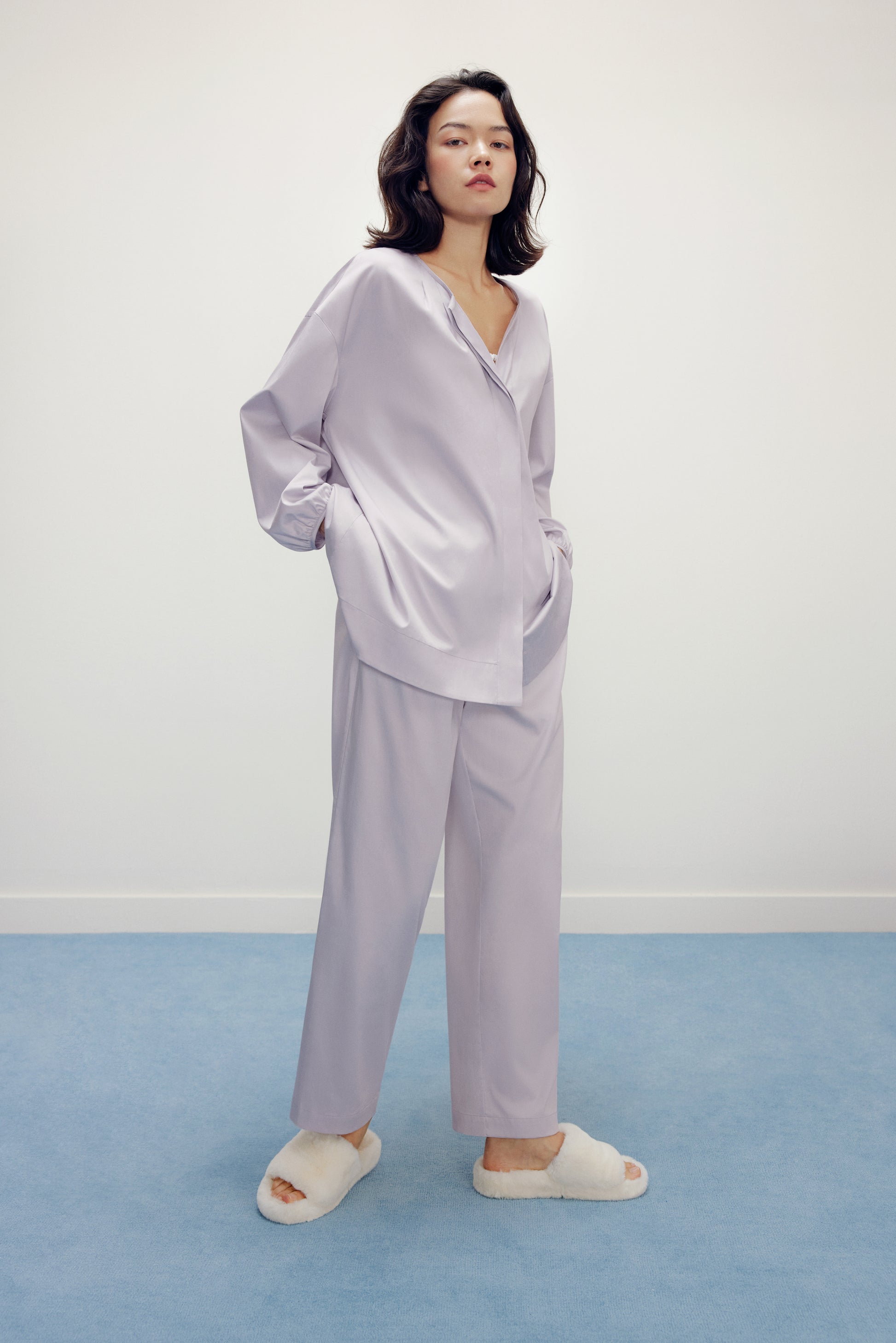 a woman wearing a purple pajama sets and white slippers 