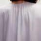 back of a woman wearing a purple pajama top