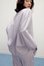 back of a woman wearing a purple pajama top