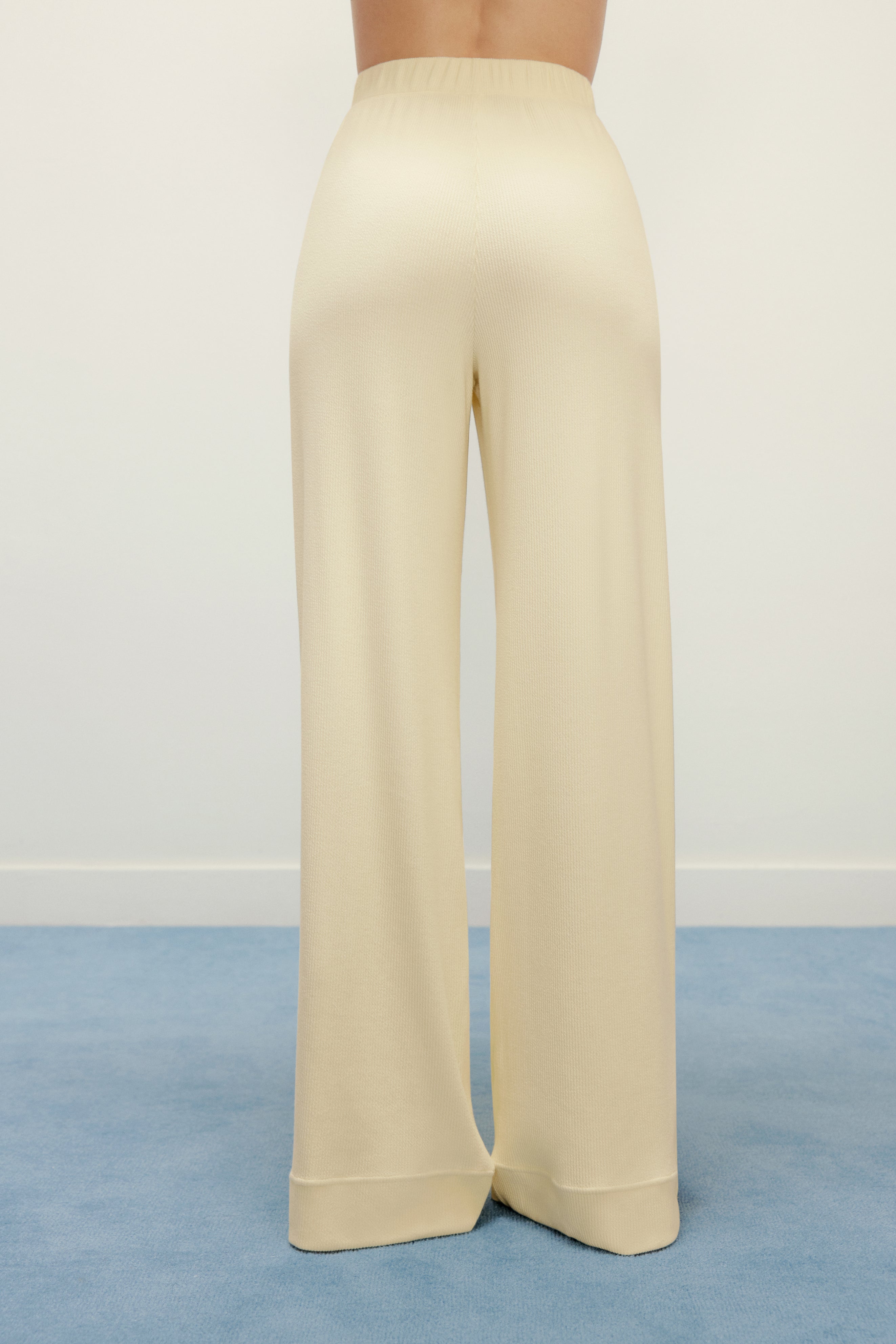 woman in yellow pajama pants from back