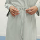 close up of woman in mint pajama longe sleeve dress with waist drawstring