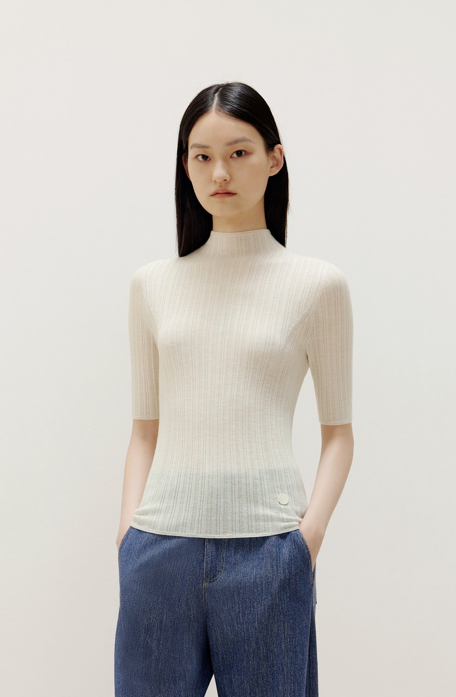 a woman wearing a white sweater and denim 