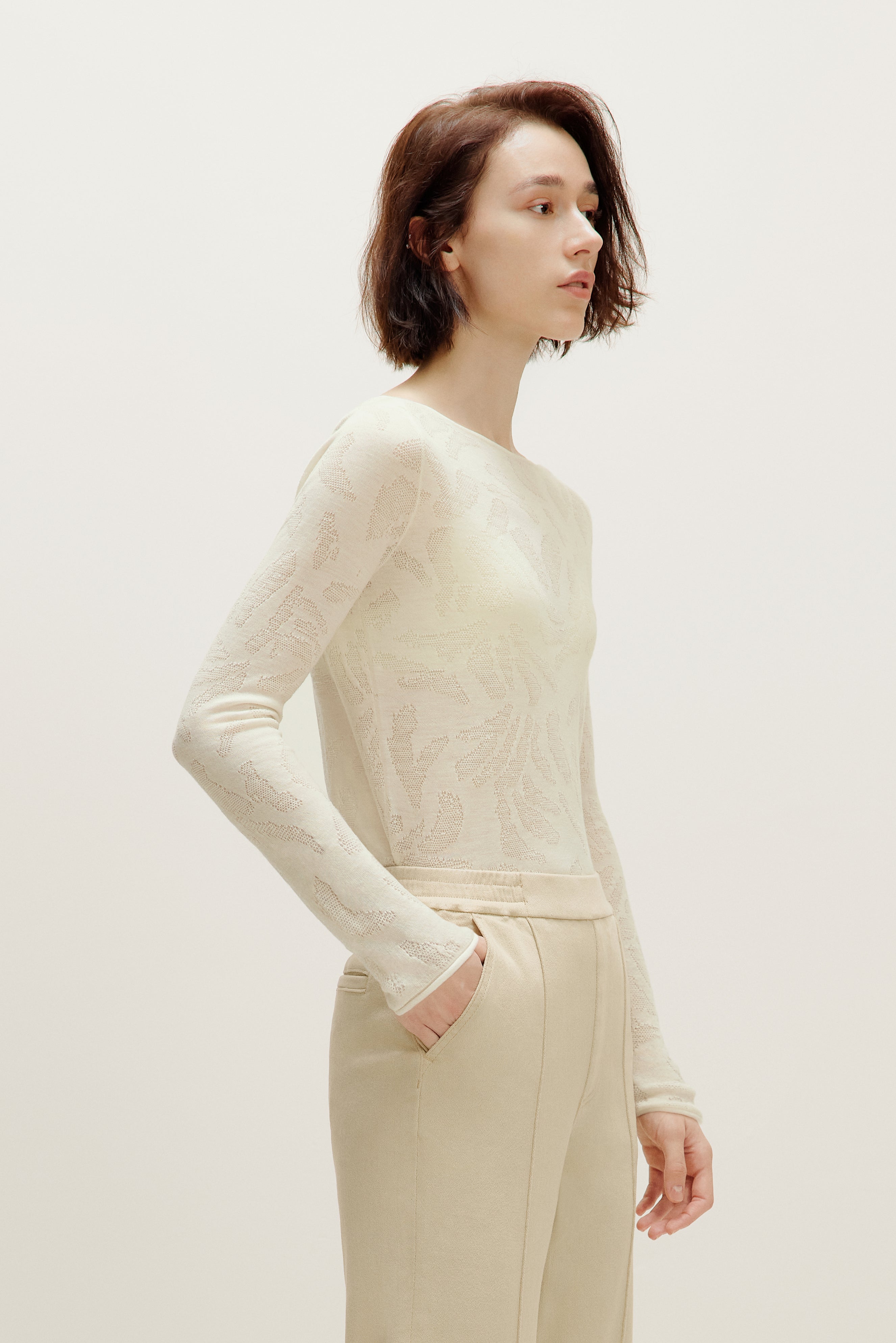 a woman wearing a white sweater and white pants