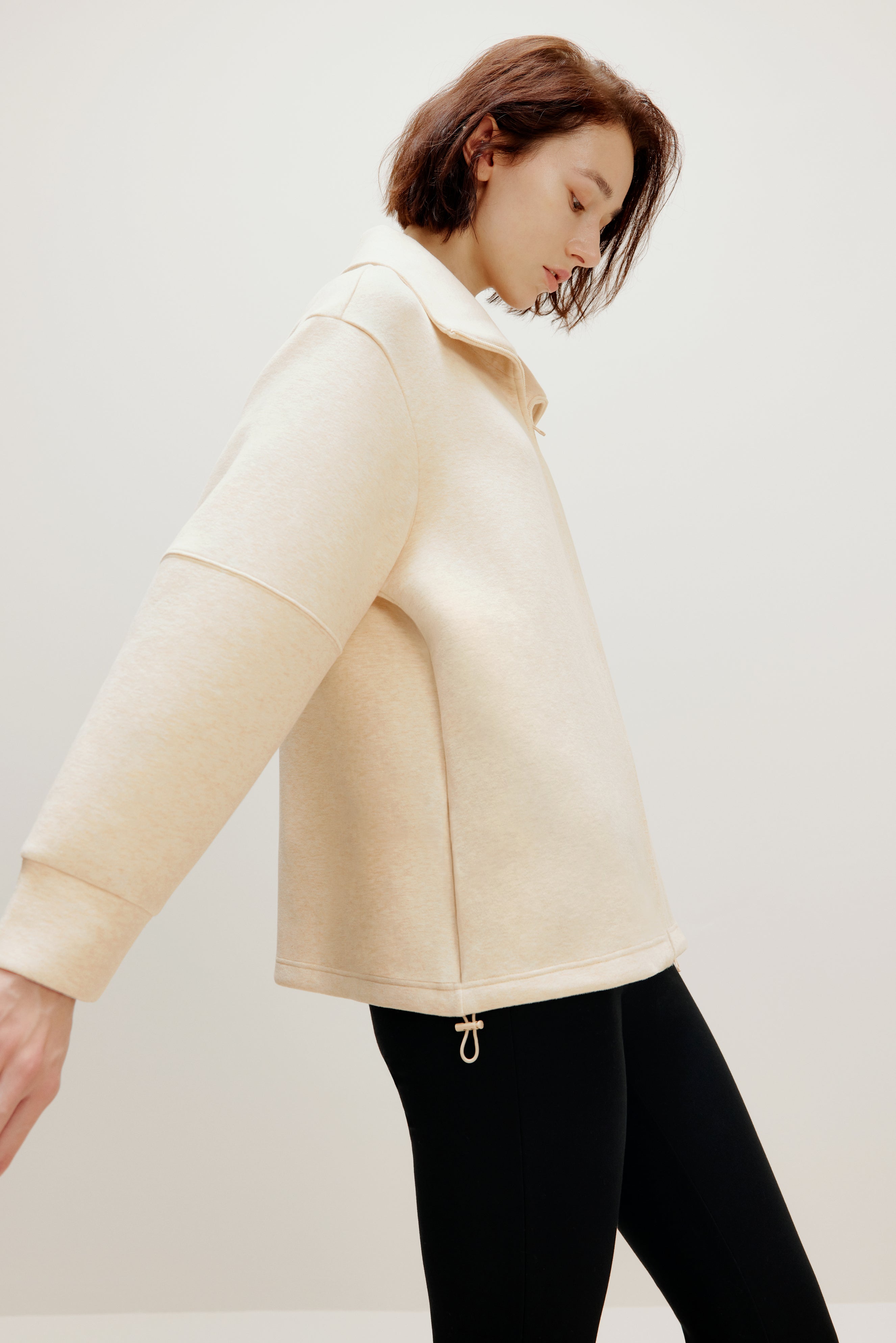 woman with off white jacket from side