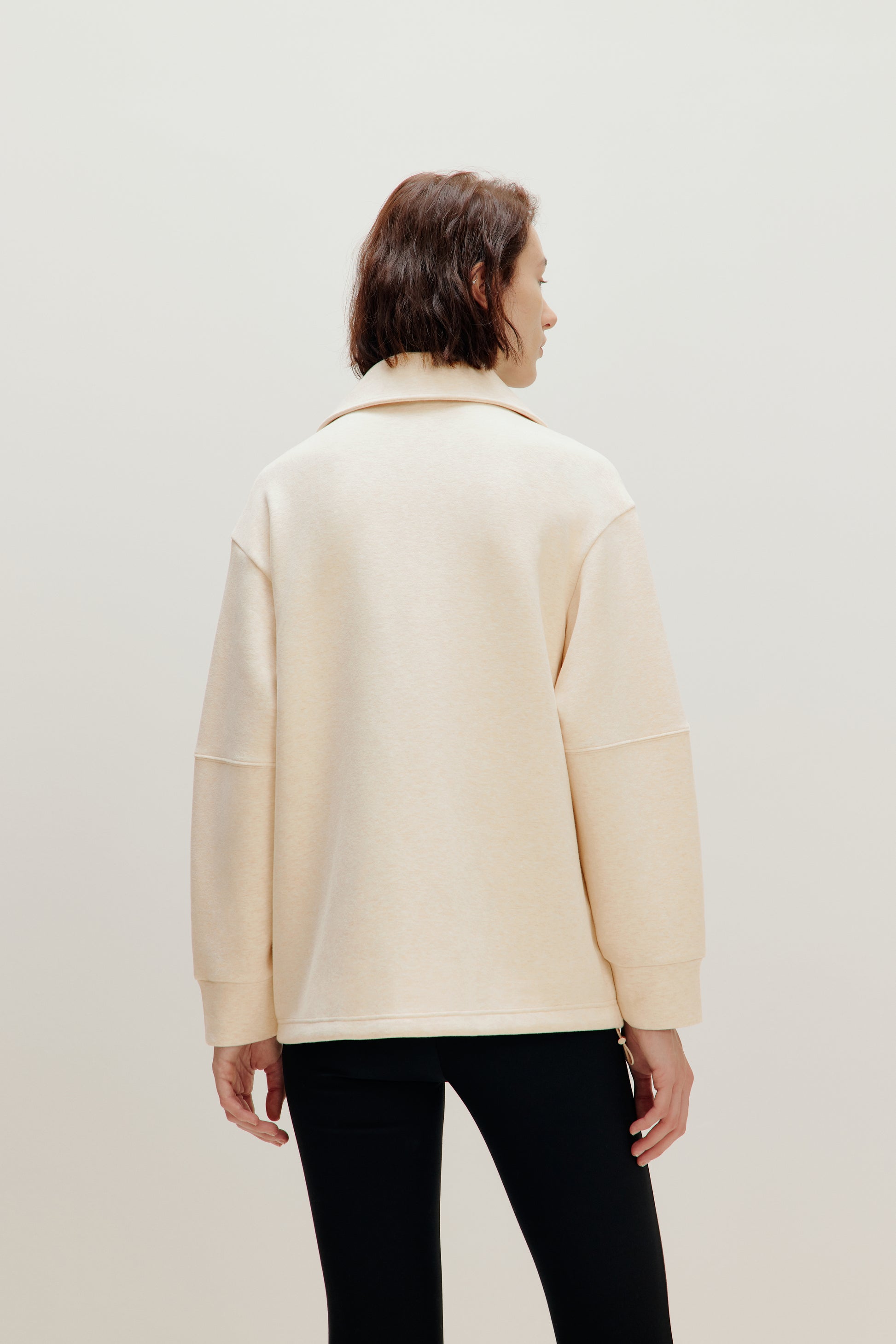 woman with off white jacket from the back