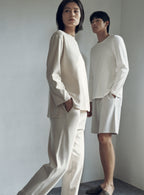 woman with cream color pull over top and pants, a man with white t-shirt and shorts