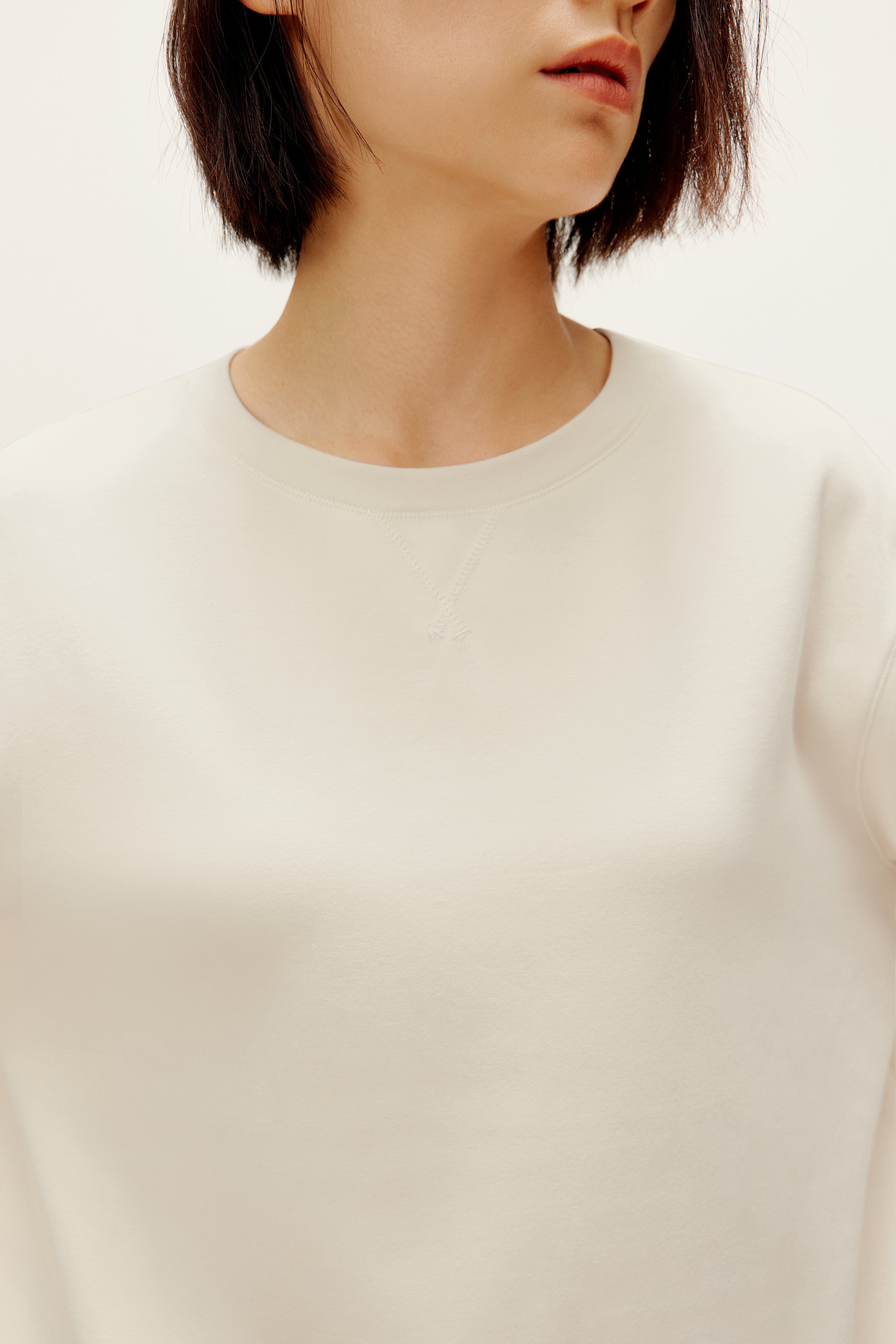 woman with cream color pull over top