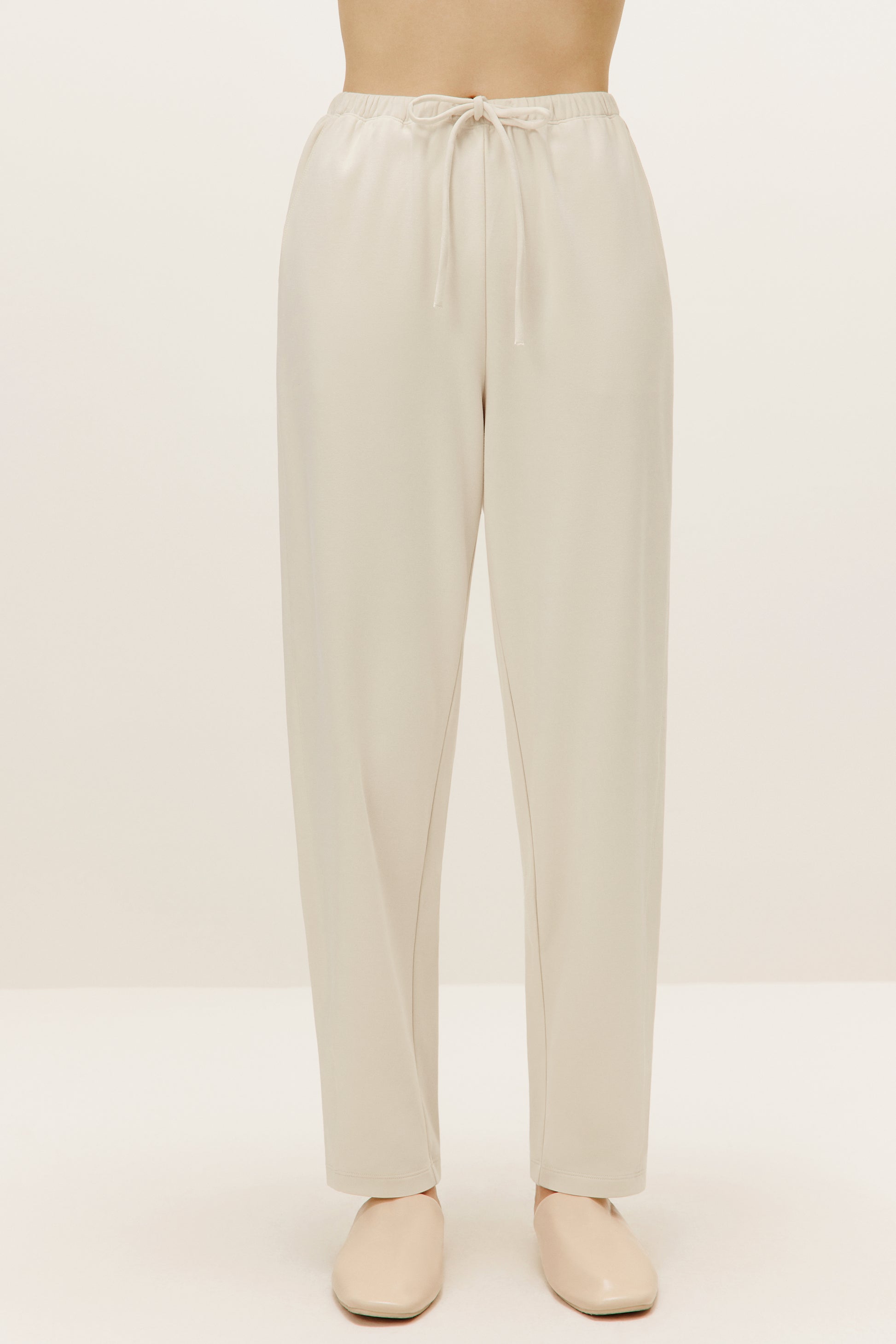 a pair of cream color pants with drawstring waist