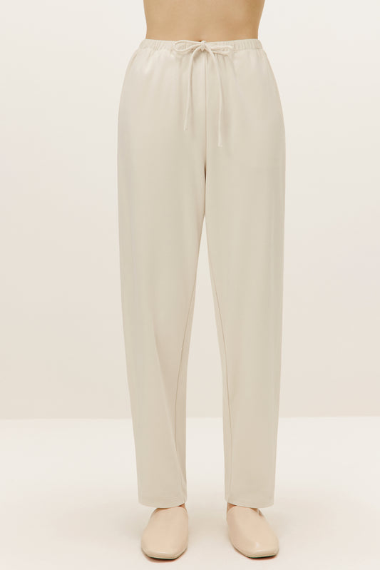 a pair of cream color pants with drawstring waist