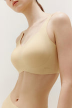 close look of woman wearing light yellow bra