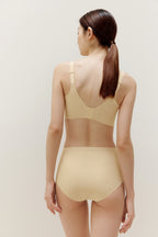 the back of woman wearing light yellow bra and matching panties