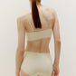 a woman wearing a set of cream color underwear  from back view