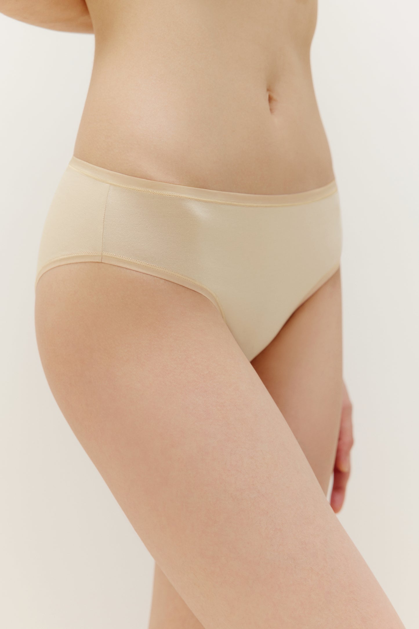 side of woman in tan brief