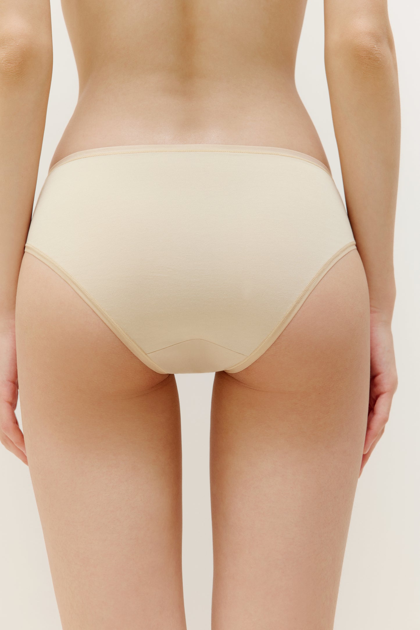 back of woman in tan brief