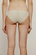 back of woman in cream color brief