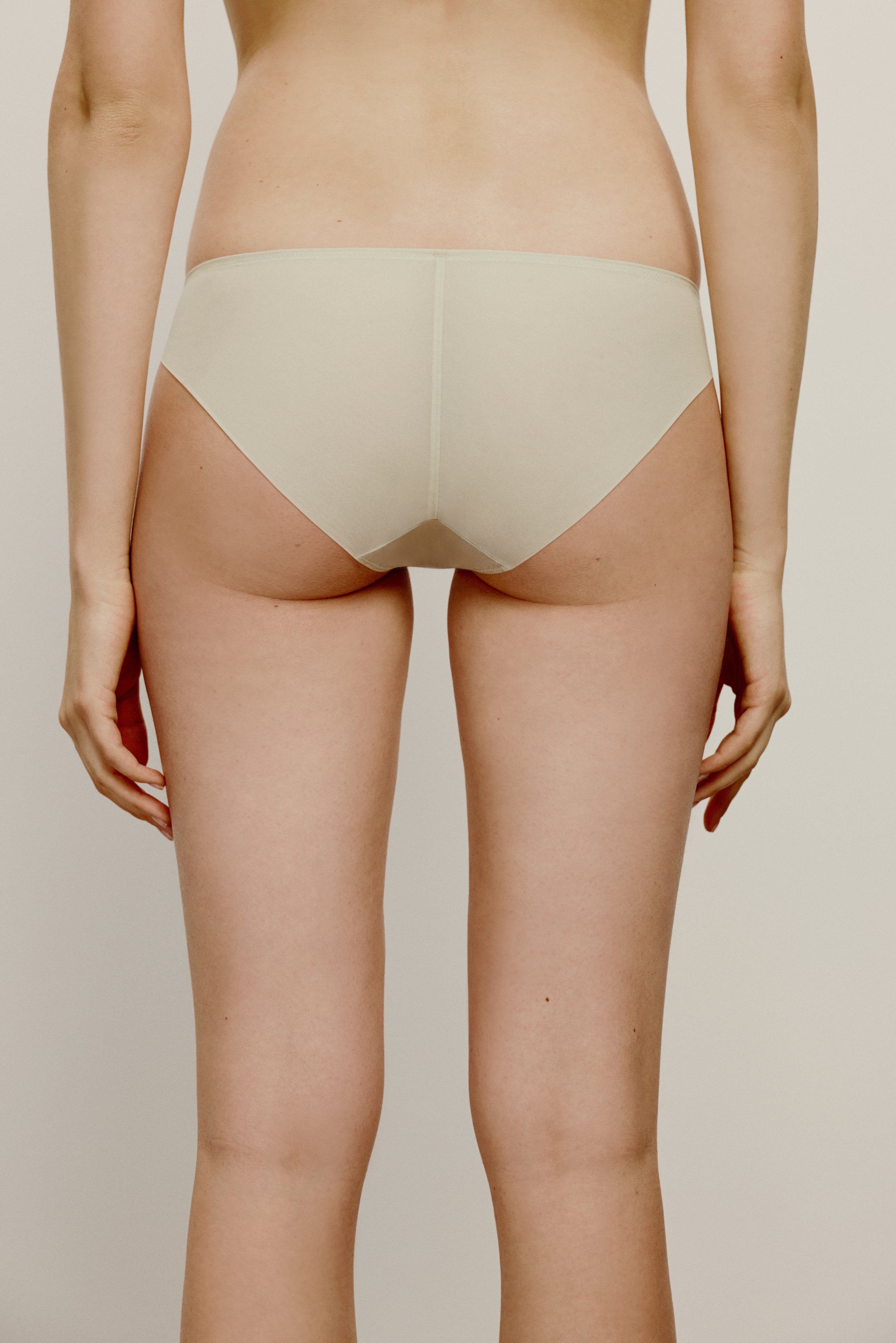 back of woman in cream color brief
