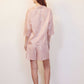 back of woman with pink pajama shirt with white sketches and matching shorts