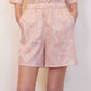 woman with pink pajama shorts with white sketches 