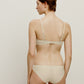 back of woman in woman in cream bra and brief