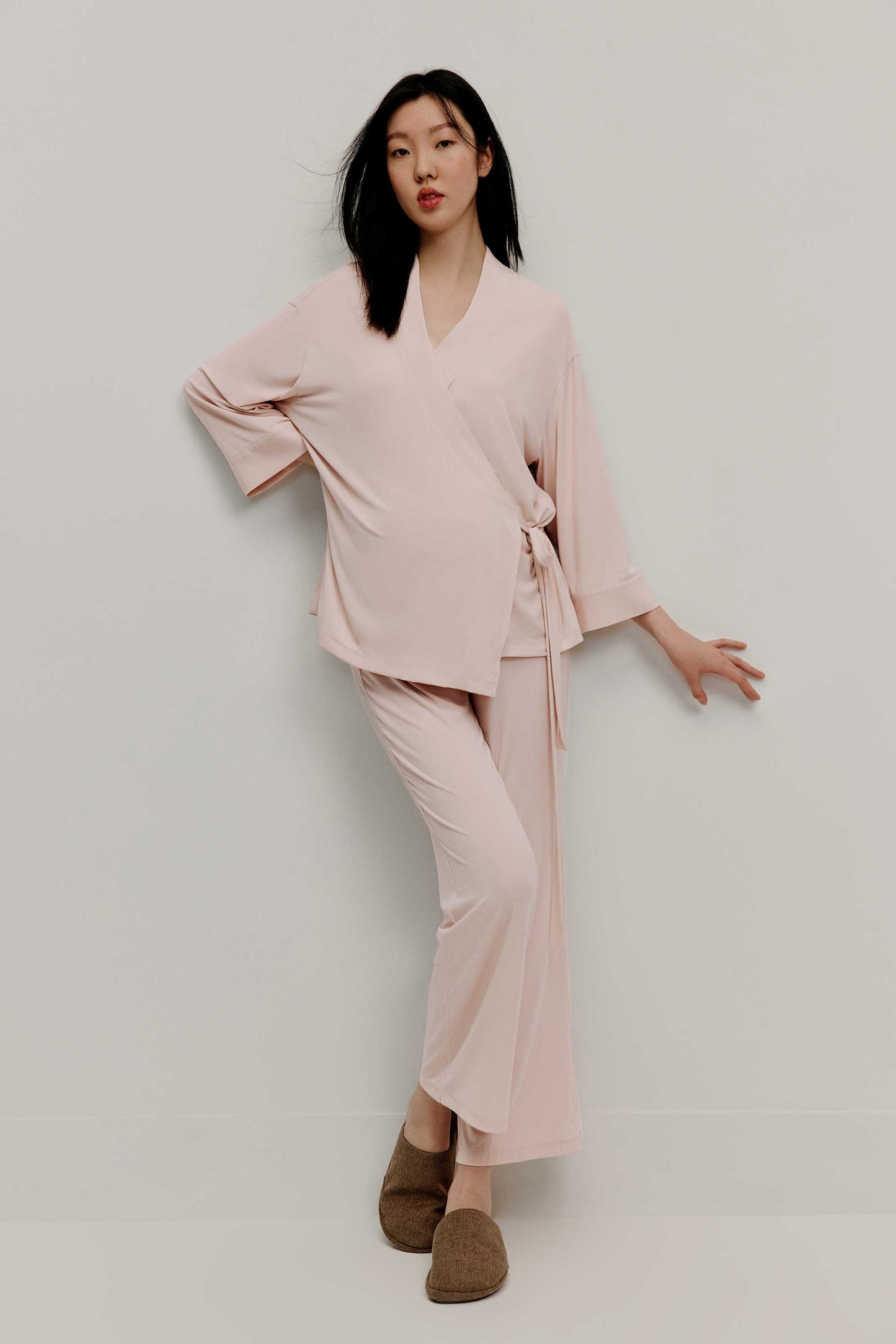 A pregnant woman wearing pink maternity pajama set