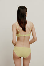 back of woman in yellow bra and brief