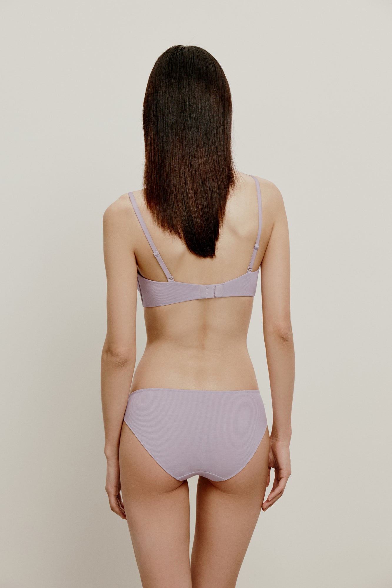 back of woman in light purple bra and brief
