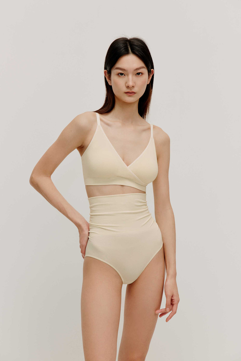 woman in cream color cross over bra and high waist brief