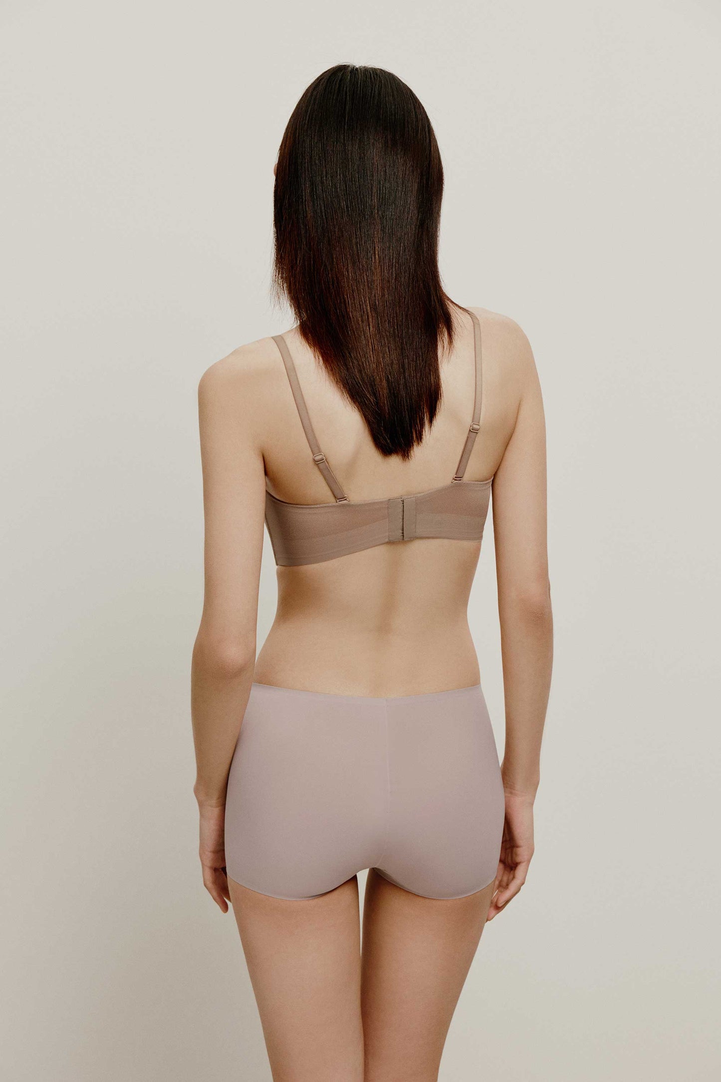 back of woman in tan color bra and light purple brief