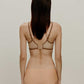 back of woman in tan bra