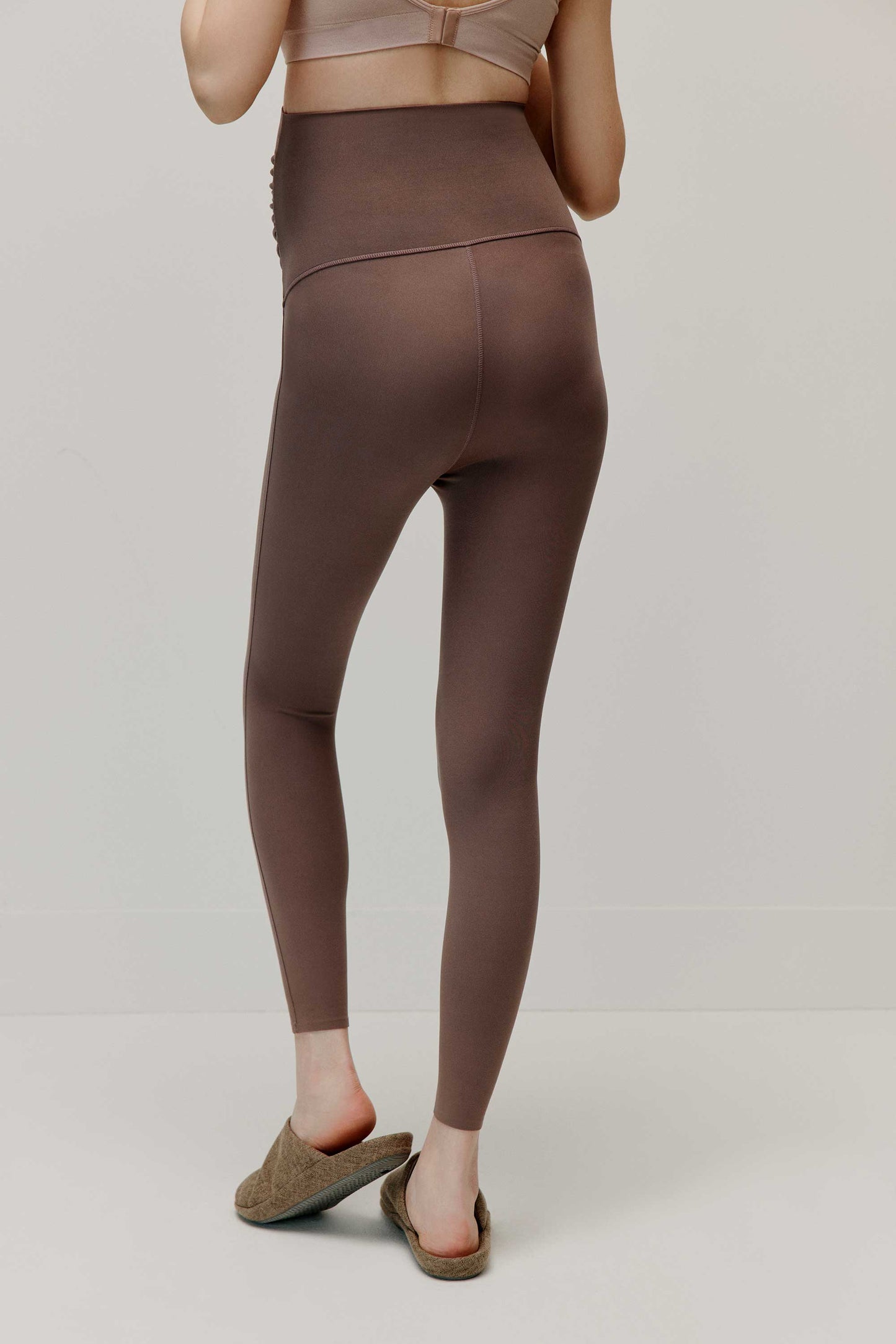 back of woman in brown leggings
