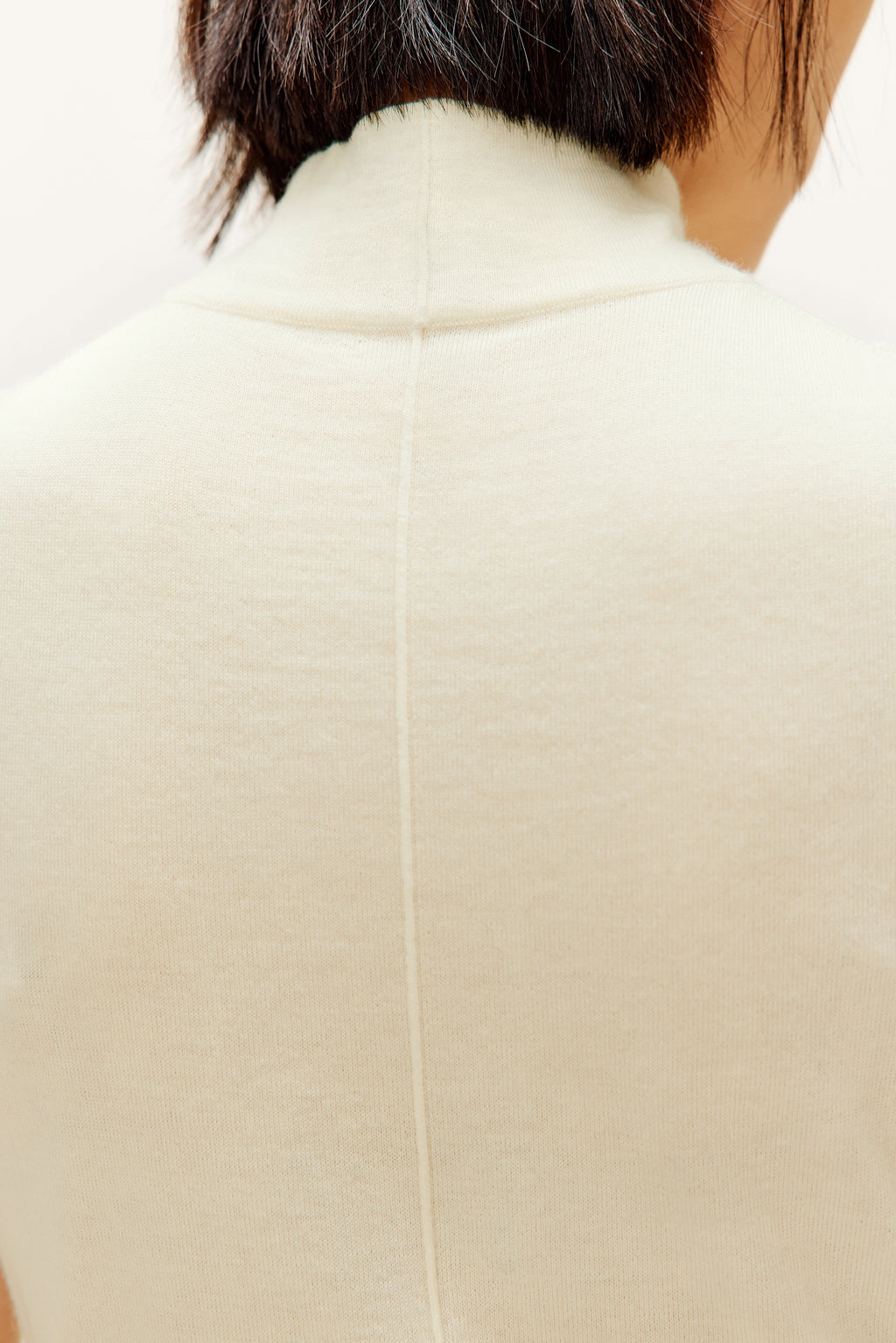 white silky wool mock neck sleeveless sweater from back