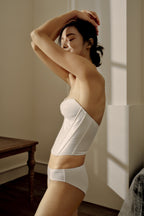 side of woman in white corset and underwear