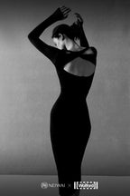 back of woman in black long sleeve top and midi skirt