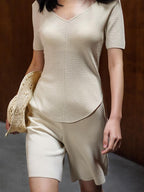 Front view of woman wearing cream knit top with matching shorts.